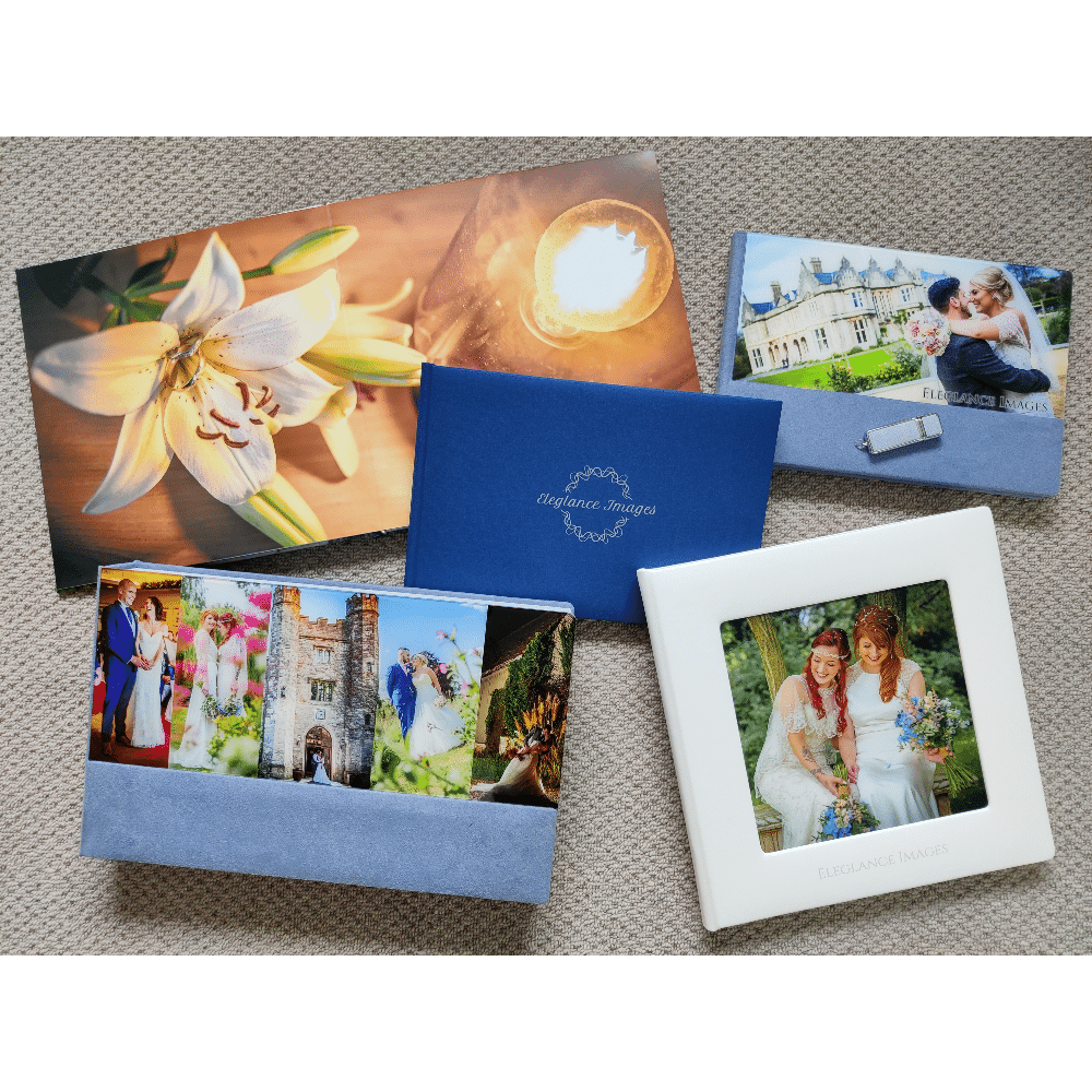 Wedding photo albums and floral prints arranged on a carpet.