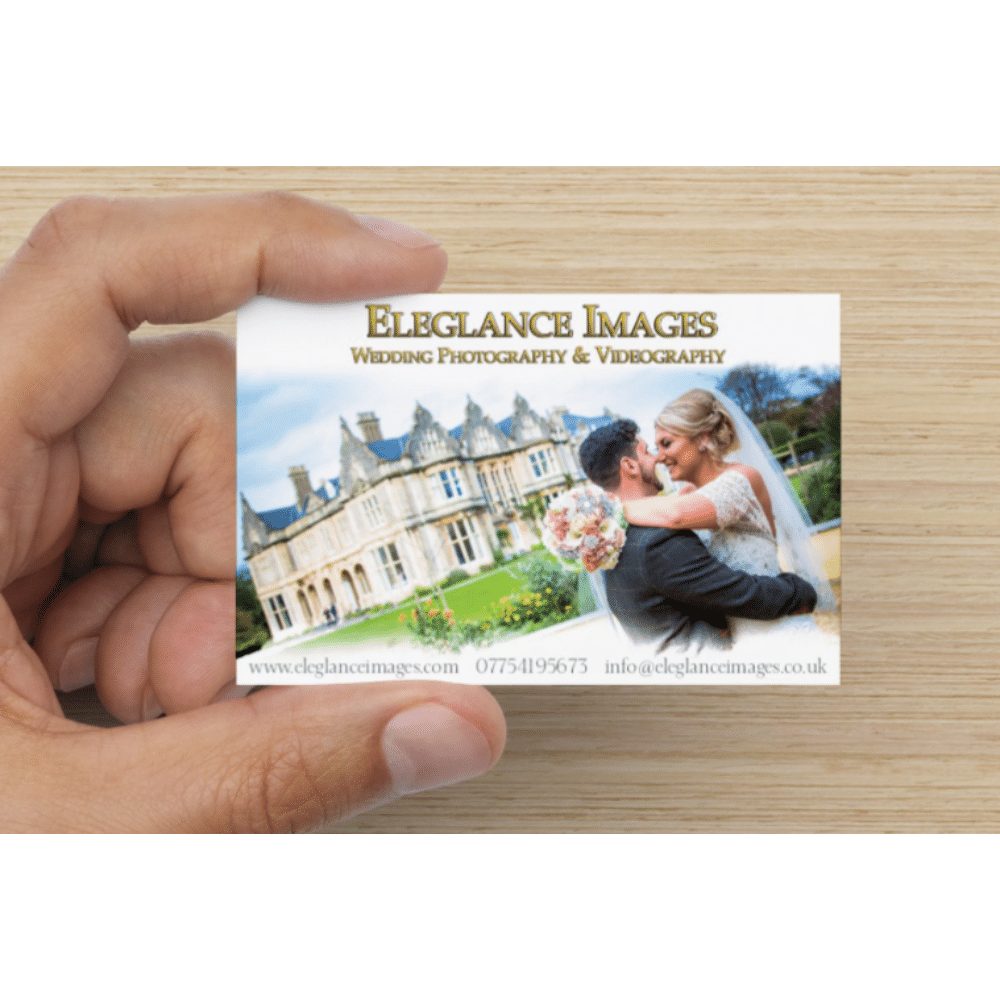 Hand holding a business card for Elegance Images, Wedding Photography & Videography, featuring a kissing bride and groom.