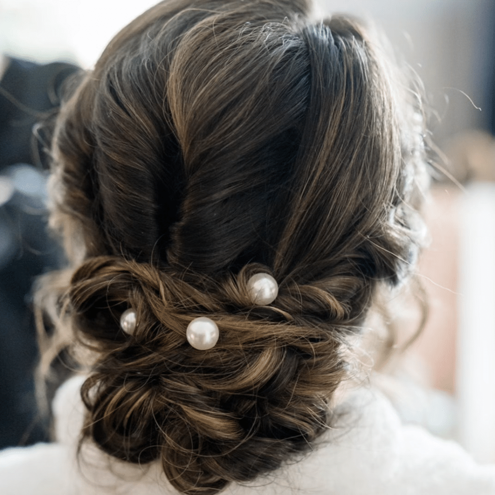 Elegant updo hairstyle adorned with pearls.