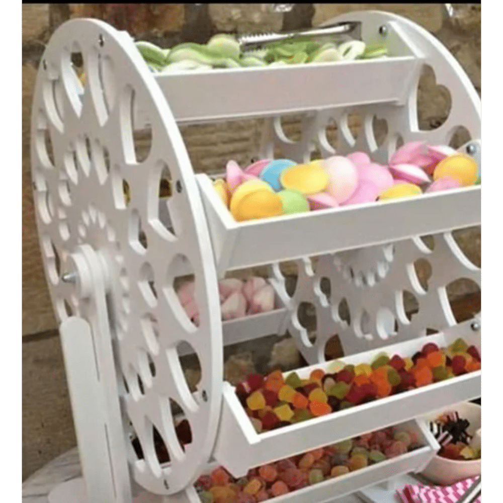 Ferris wheel candy display with various colorful sweets in trays.
