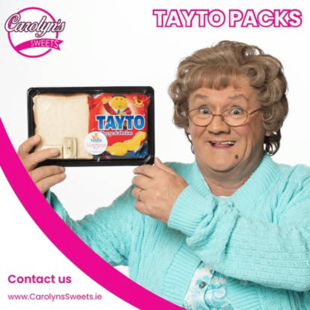 Elderly person smiling and holding a Tayto snack pack next to a sandwich, with Carolyn's Sweets branding.