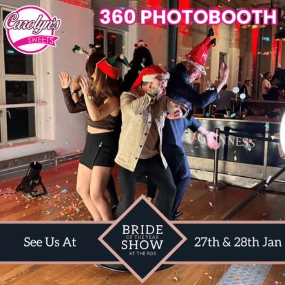 People in festive hats posing in a 360 photobooth at Carolyn's Sweets event. Bride of the Year Show banner displayed.