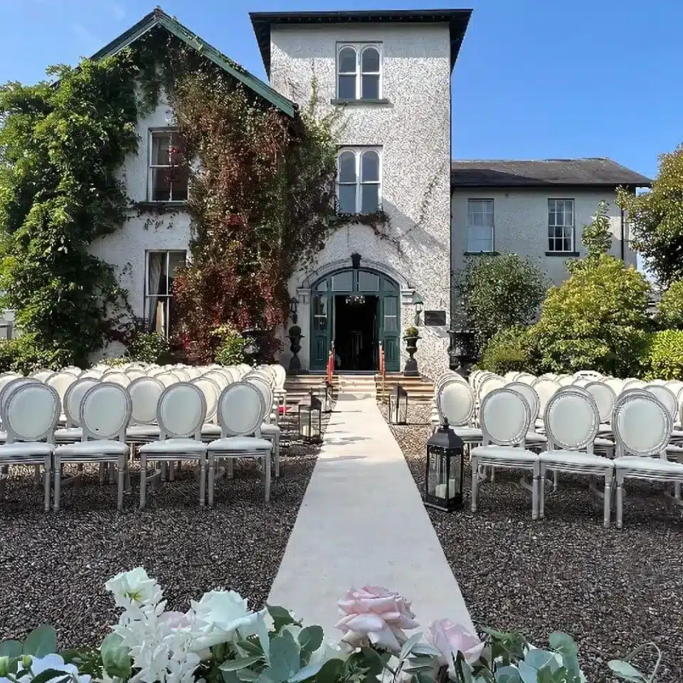 Outdoor wedding ceremony setup at Cork House Hotel & Spa with aisle seating and entrance backdrop.