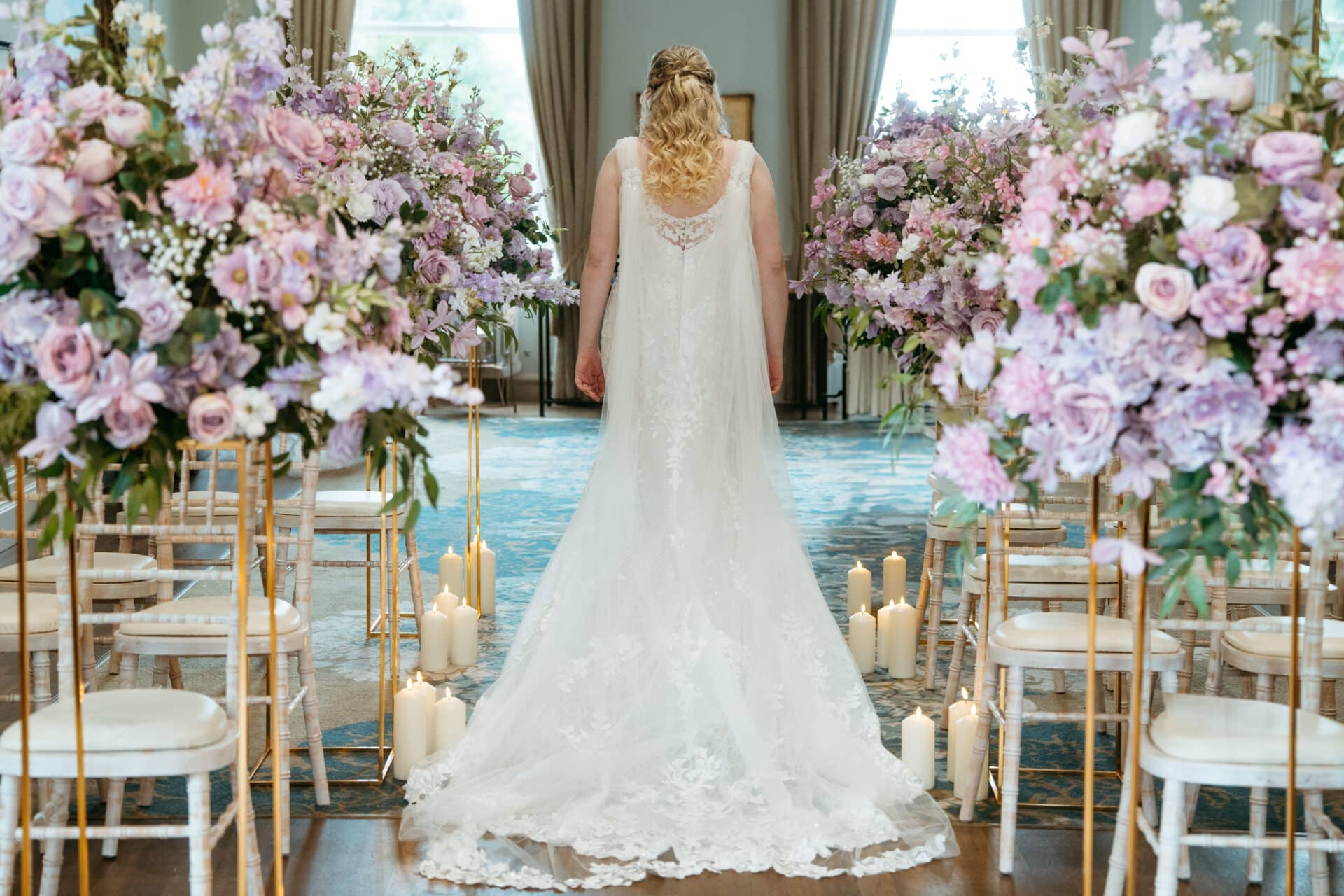 Bride walking up the aisle surrounded by florals in Northern Ireland by EVENTS BY Cassidy McCleans
