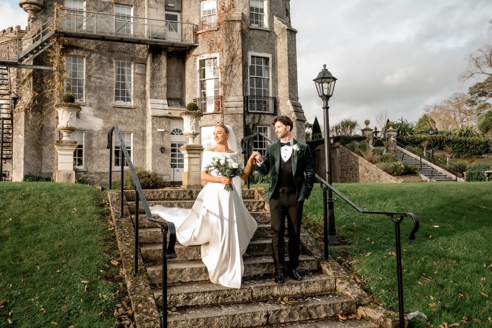 Bride and groom walking down steps at Bellingham Castle.