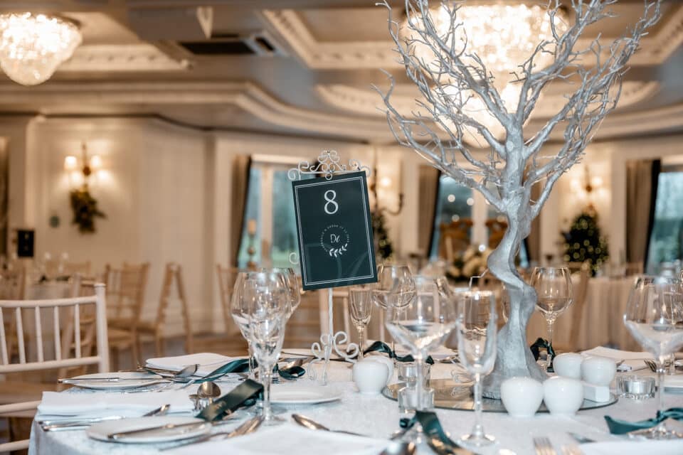 Elegant wedding table setting at Bellingham Castle with table decor and number eight sign.
