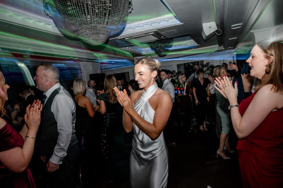 Guests dancing and clapping in a lively celebration at Bellingham Castle.