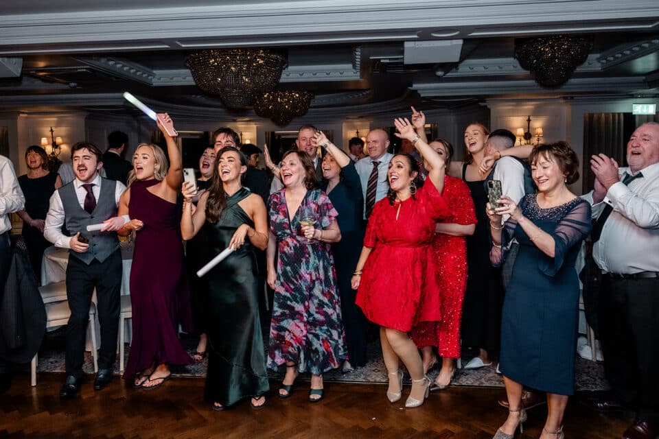 Guests celebrating at a lively wedding reception at Bellingham Castle.