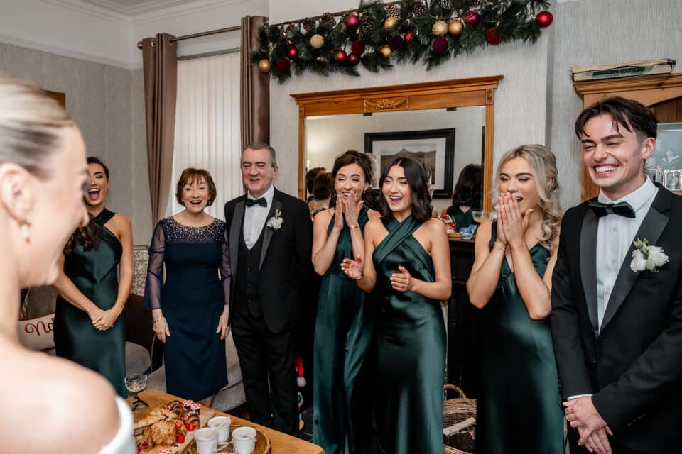Bride shares joyful moment with wedding party at Bellingham Castle.