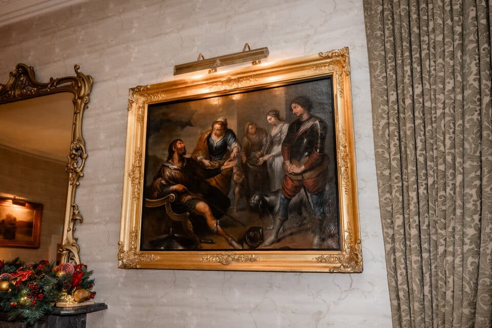 Ornate framed painting depicting historical figures in a lavishly decorated room.