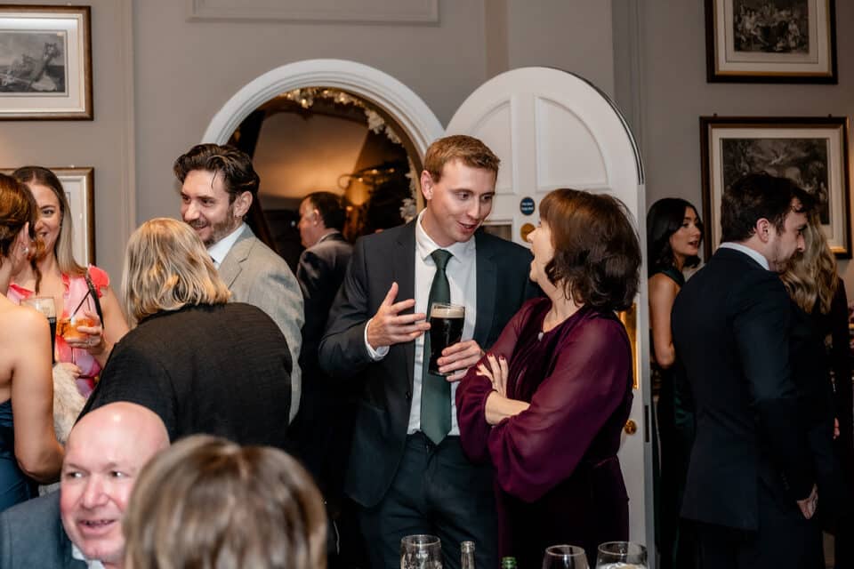 Guests socializing at a formal event inside Bellingham Castle.