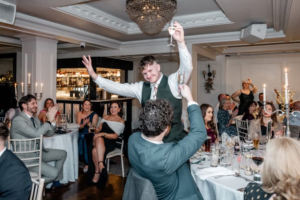 Wedding celebration at Bellingham Castle with guests cheering and toasting.