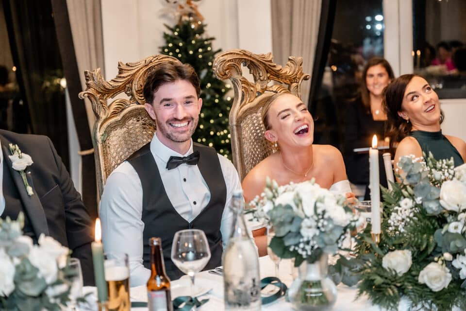 Bride and groom laughing at their wedding reception at Bellingham Castle.