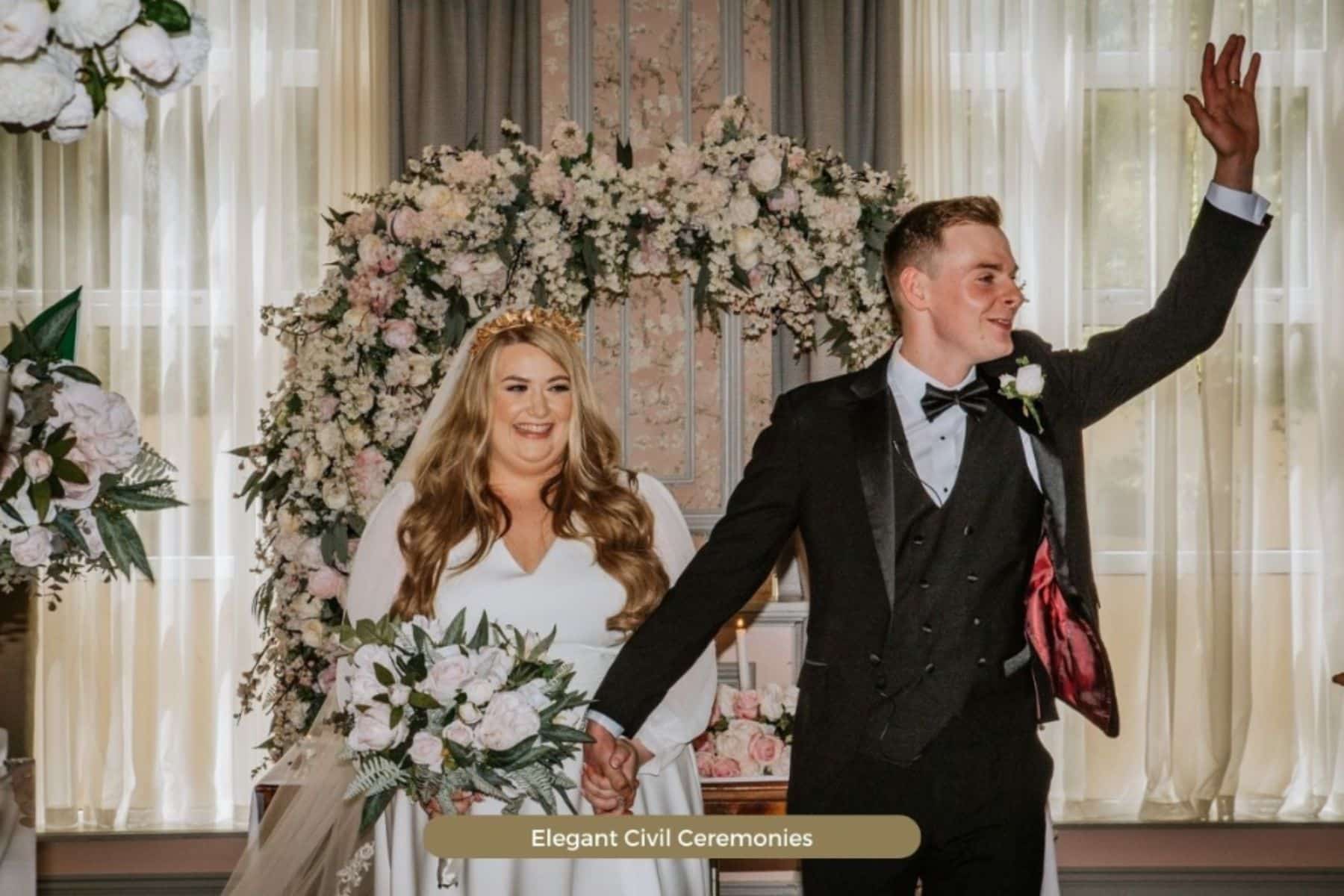 Bride and groom celebrating in front of floral arch at Four Seasons Hotel Monaghan.