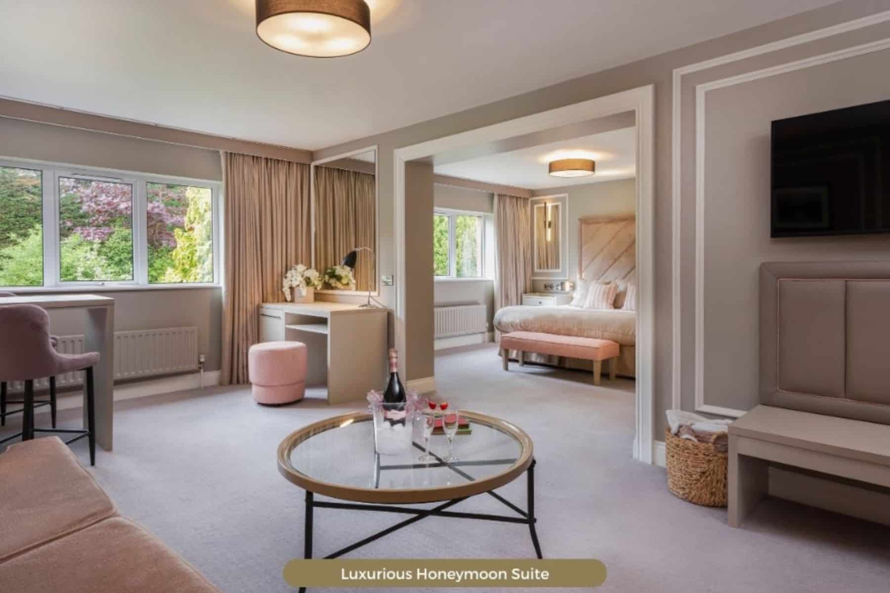 Luxurious honeymoon suite with modern decor, featuring a cozy bed, seating area, and a scenic window view.
