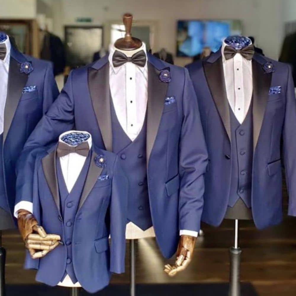 Blue tuxedos with black lapels on mannequins; includes a child-sized suit.