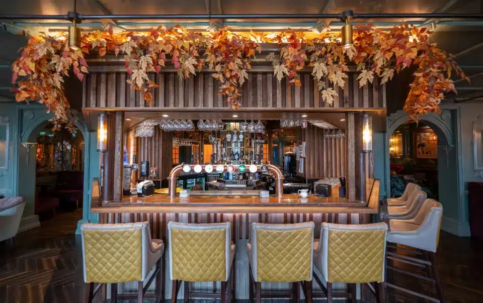 Elegant bar interior with floral decorations and seating.