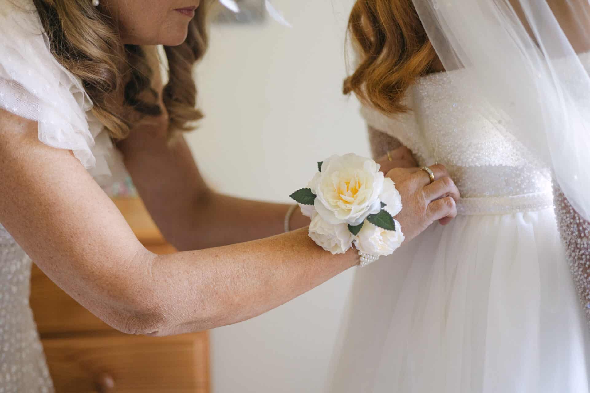 A special bridal preparation moment as Natalie’s wedding dress is fastened before her Darver Castle ceremony.