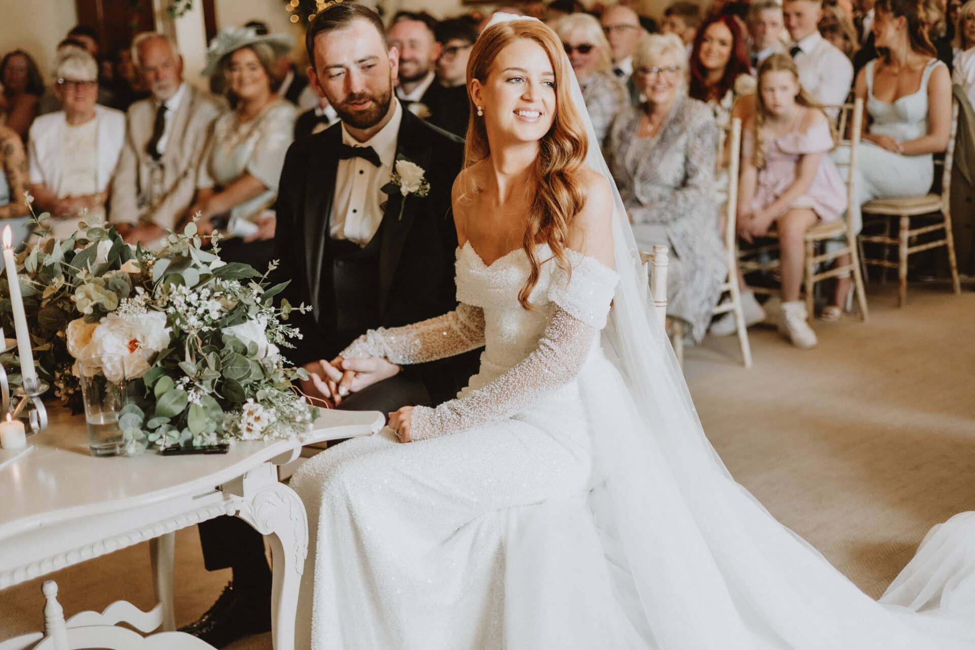 Natalie and Stephen during their wedding ceremony at Darver Castle, surrounded by family and friends as they exchange vows.