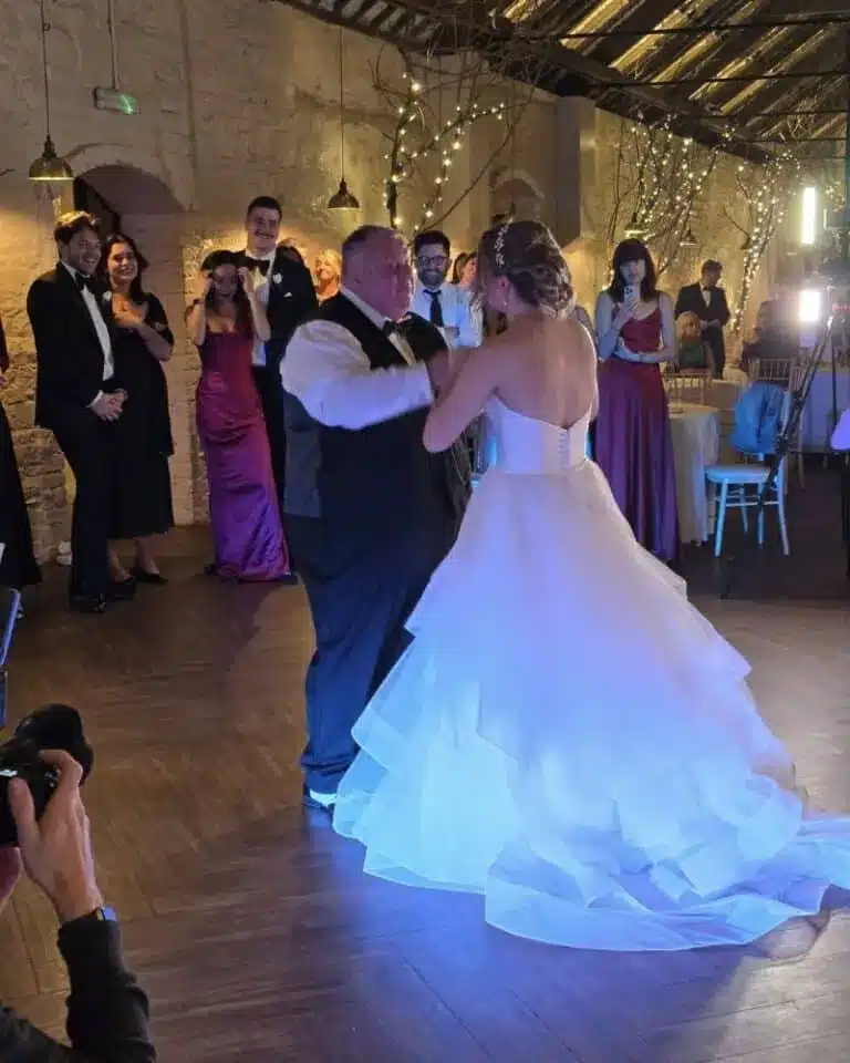 Bride dancing with band performance at wedding reception featured in vendor listing card.