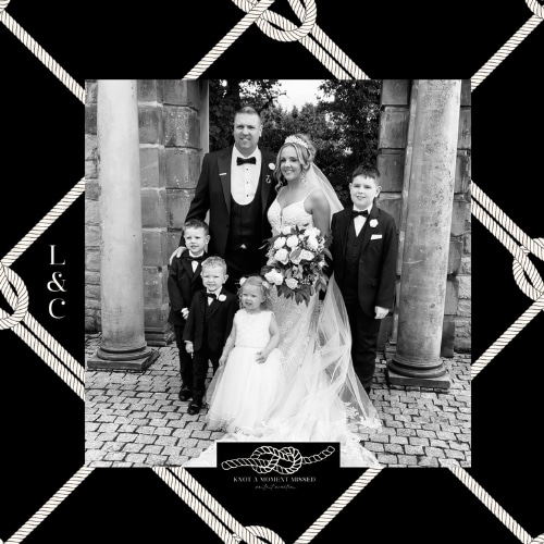 A family posing for a formal wedding portrait in front of stone columns.