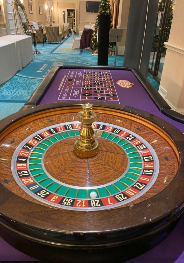 Roulette wheel and betting table in a casino setting.