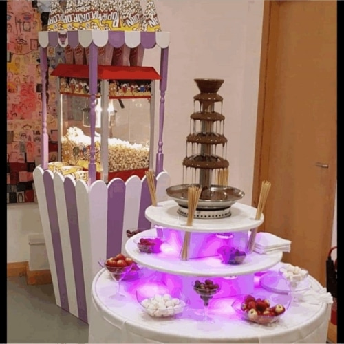 Chocolate fountain and popcorn stand at a party setup.