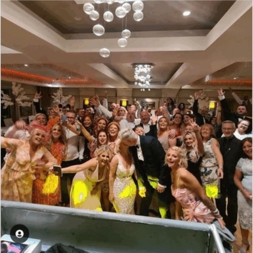 Group of people smiling and posing for a photo at a party in a decorated indoor setting.