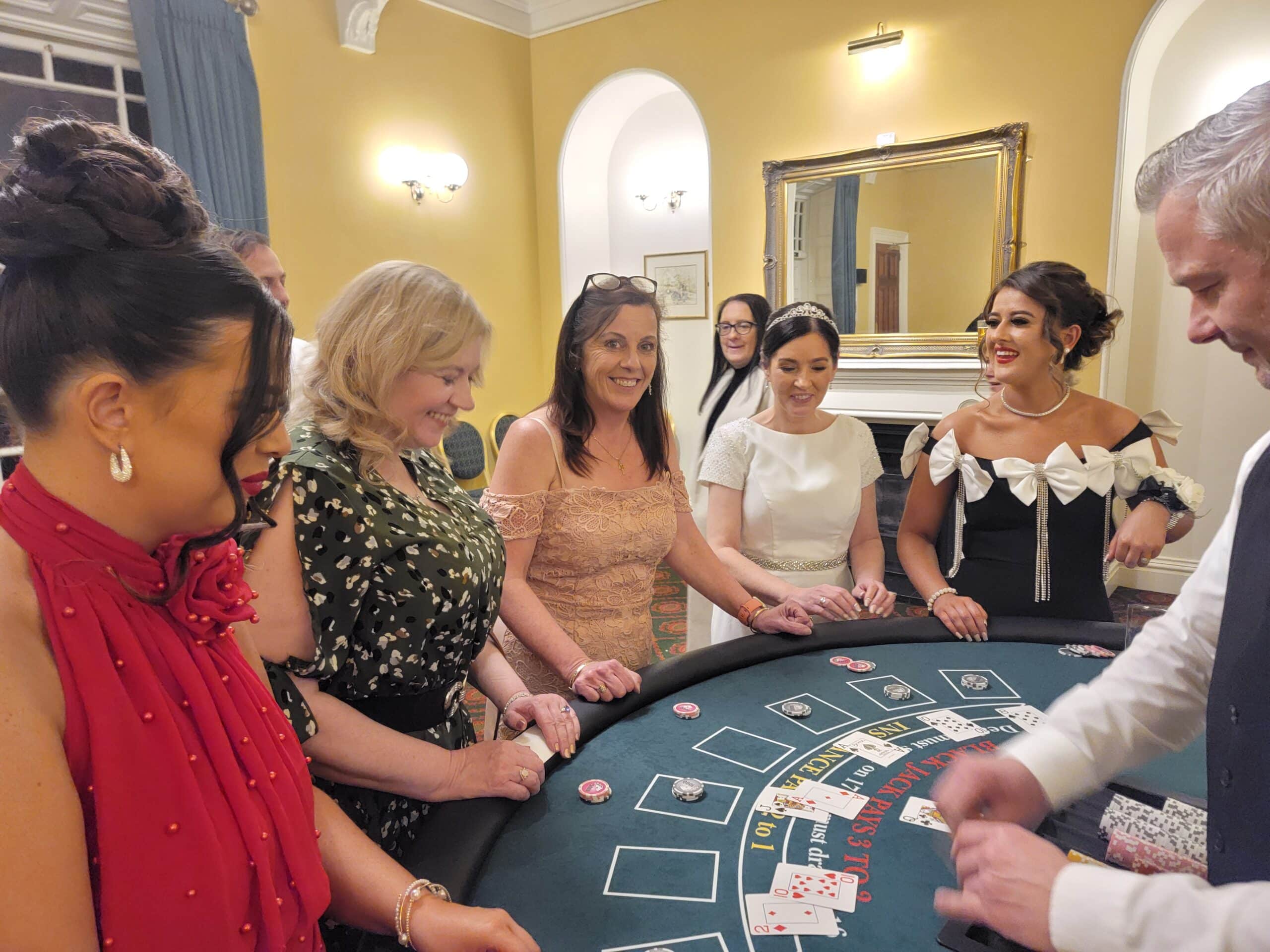 Group of people playing at a casino table in an elegant room, smiling and engaged.