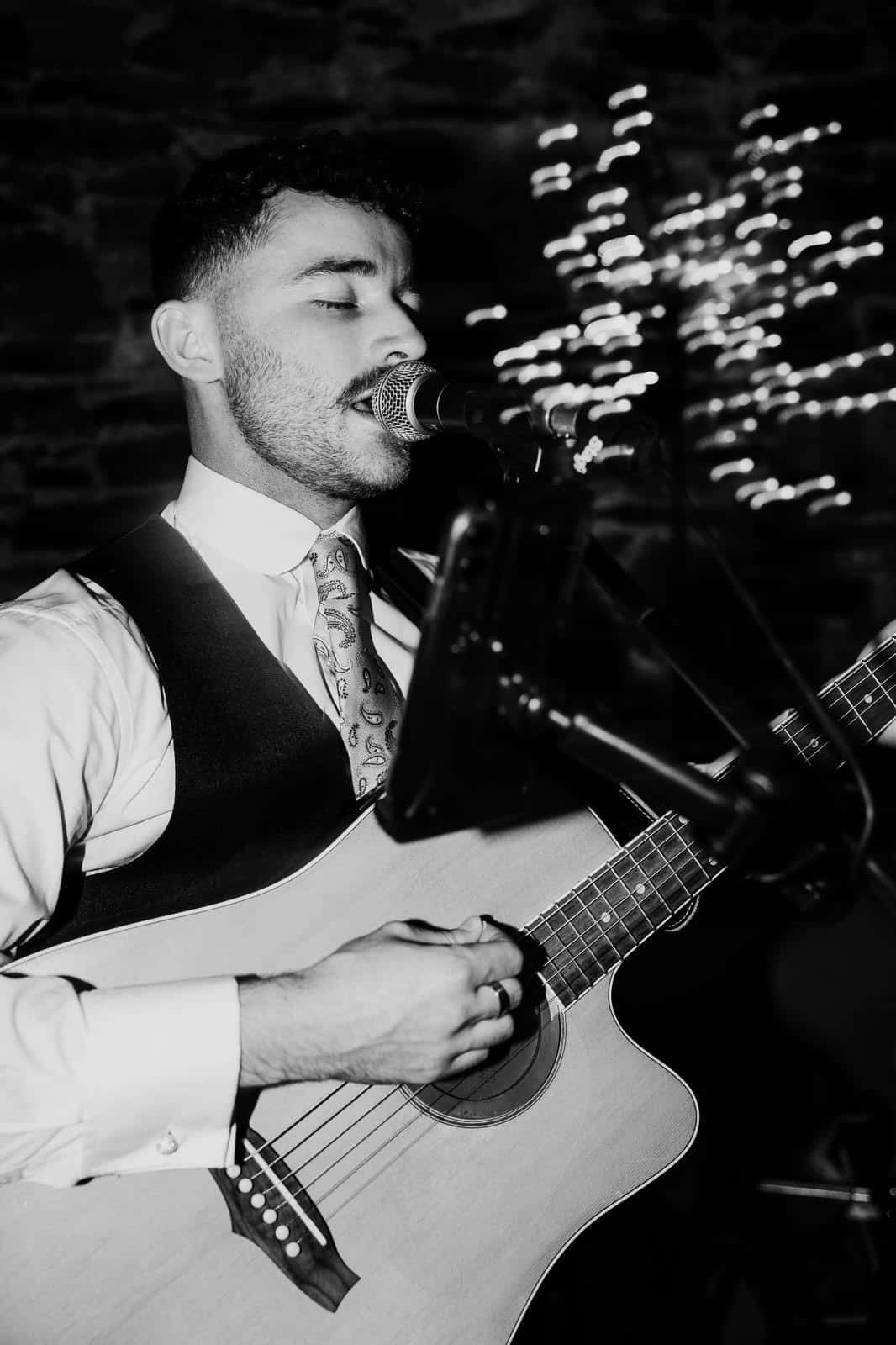 Musician singing and playing guitar during a performance.