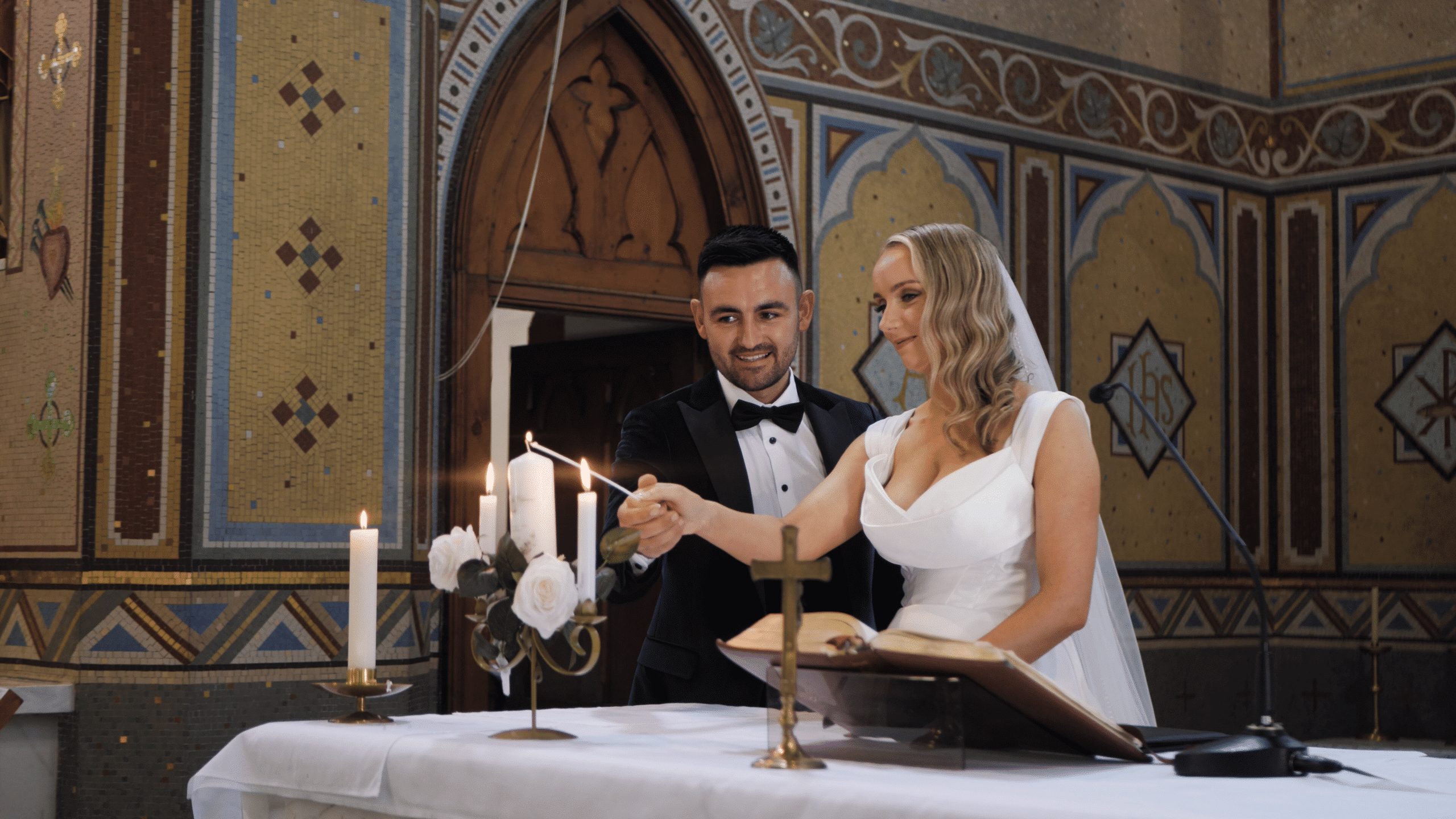 Bride and groom lighting candles during wedding ceremony in church.