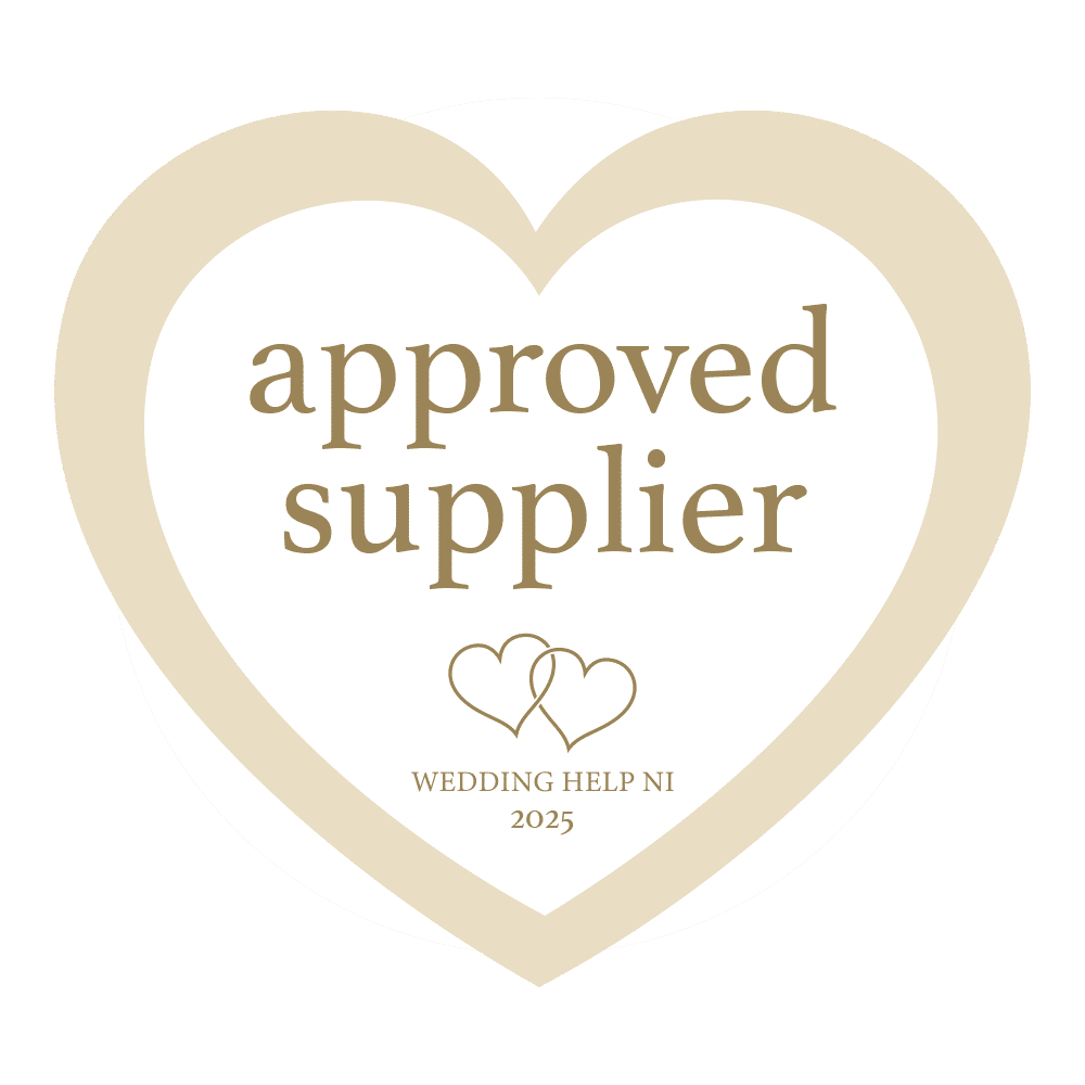 Heart-shaped badge reading "approved supplier" with "Wedding Help NI 2025" and interlocking hearts.