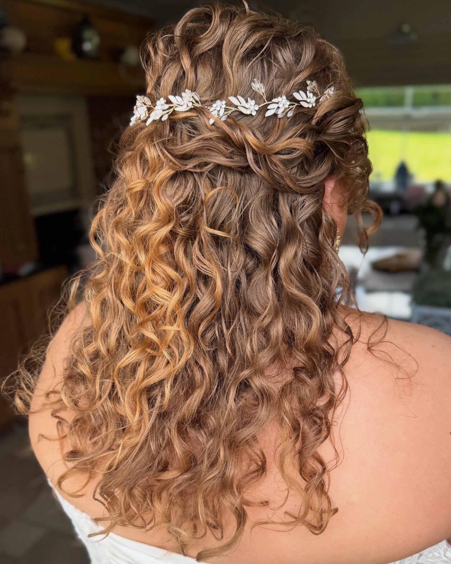 Curly hair styled with a decorative floral hair accessory.