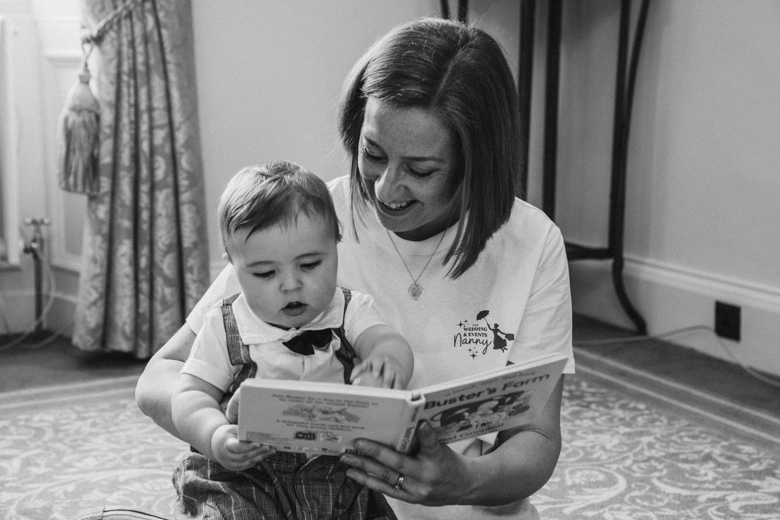 Woman reading a book to a baby in a cozy room.