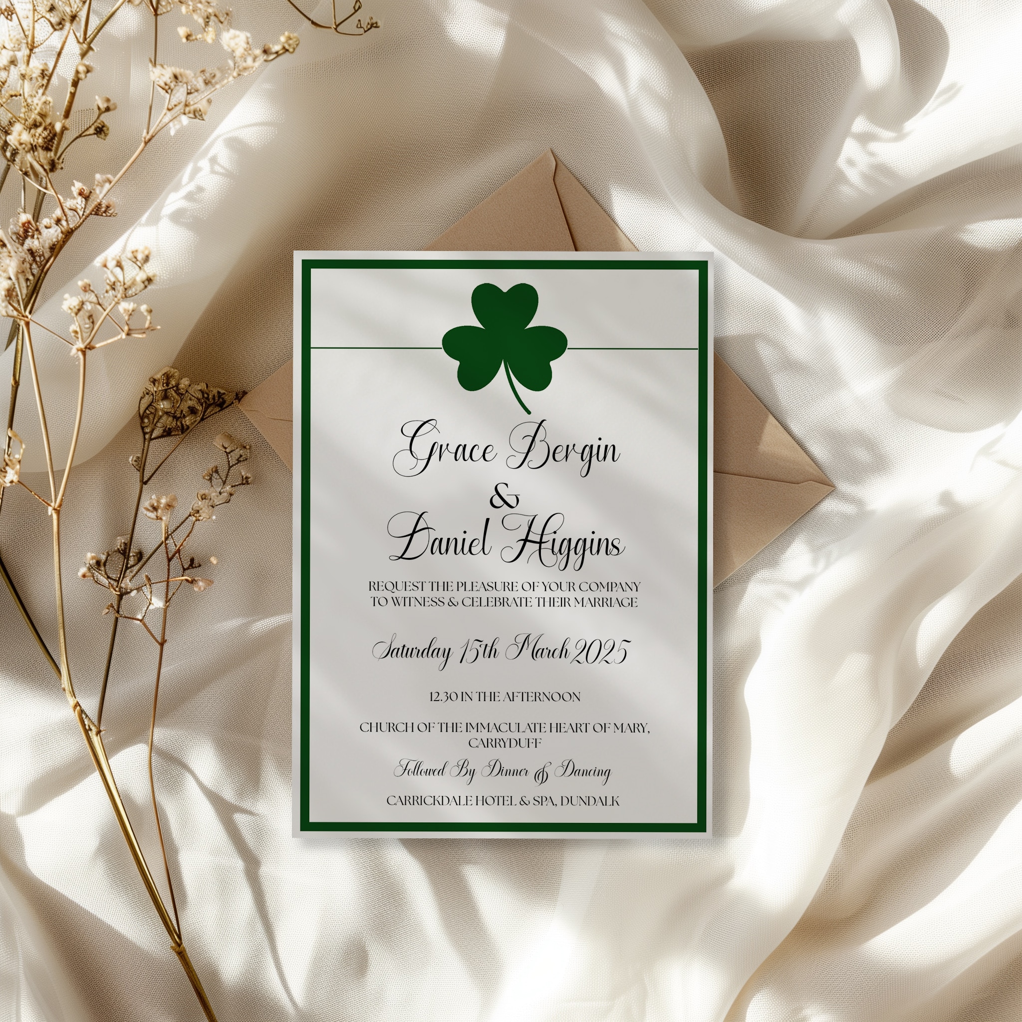 Wedding invitation on textured fabric with dried flowers and shamrock design.