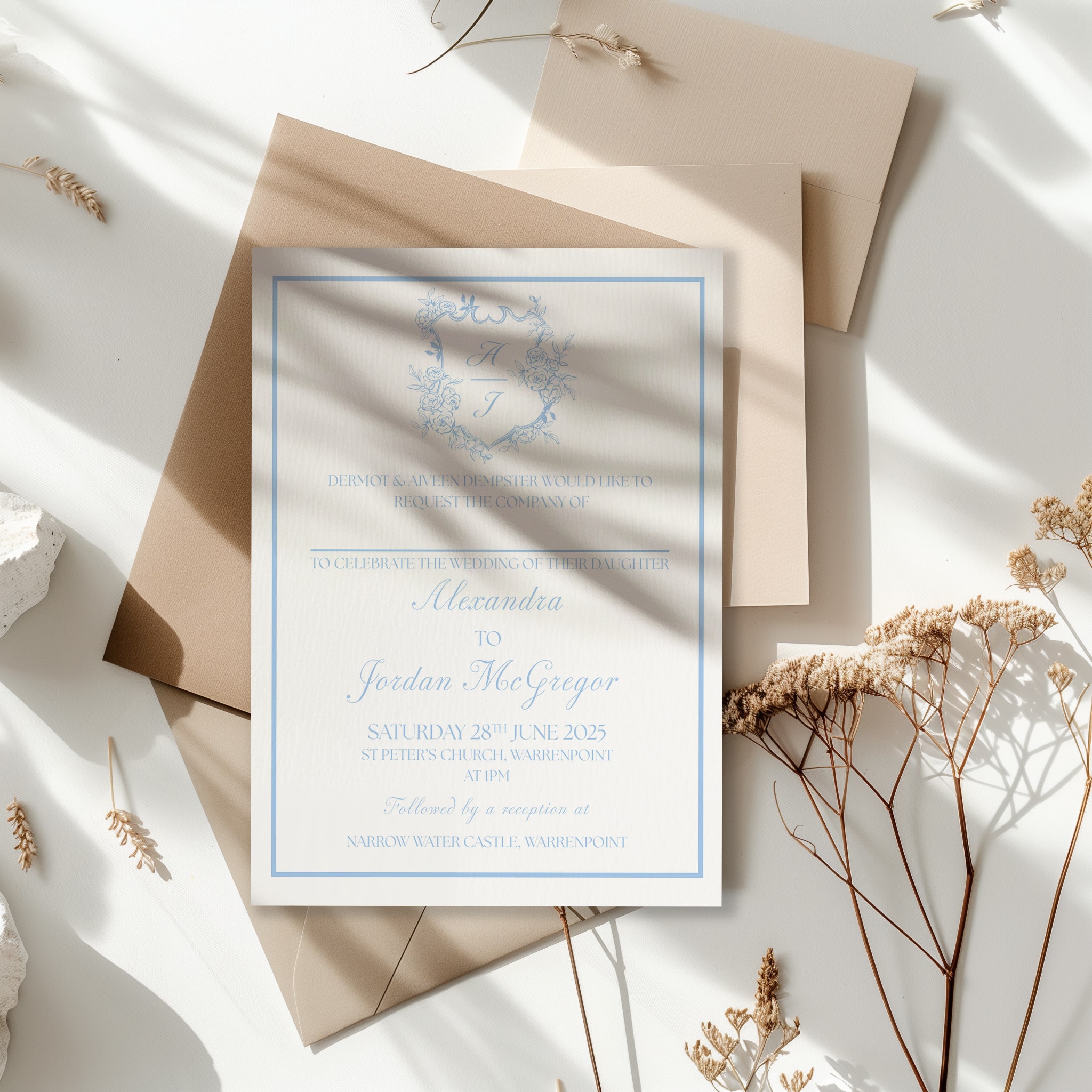 Wedding invitation card on beige envelopes with floral elements and shadows.