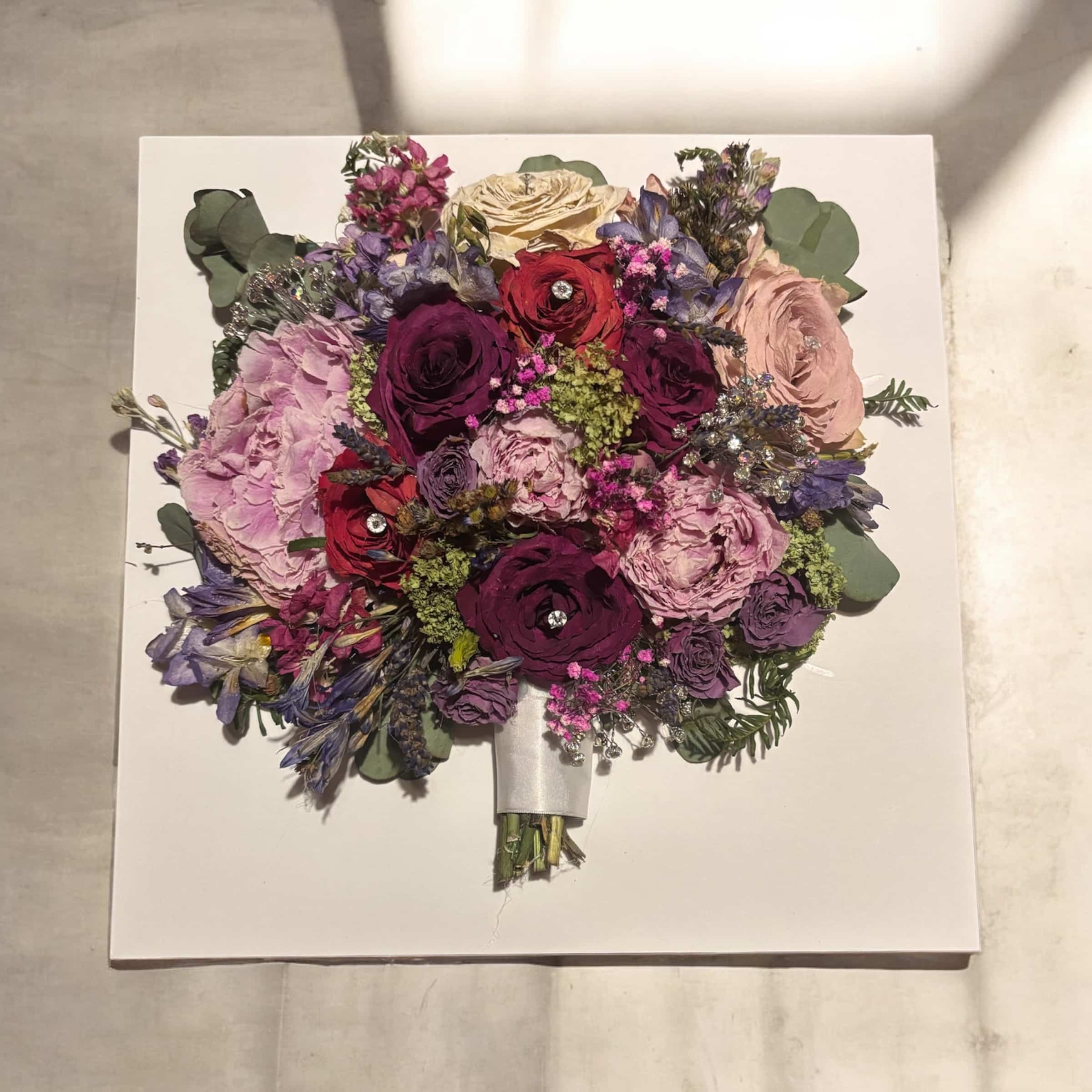 A colorful bouquet of preserved flowers on a white background.