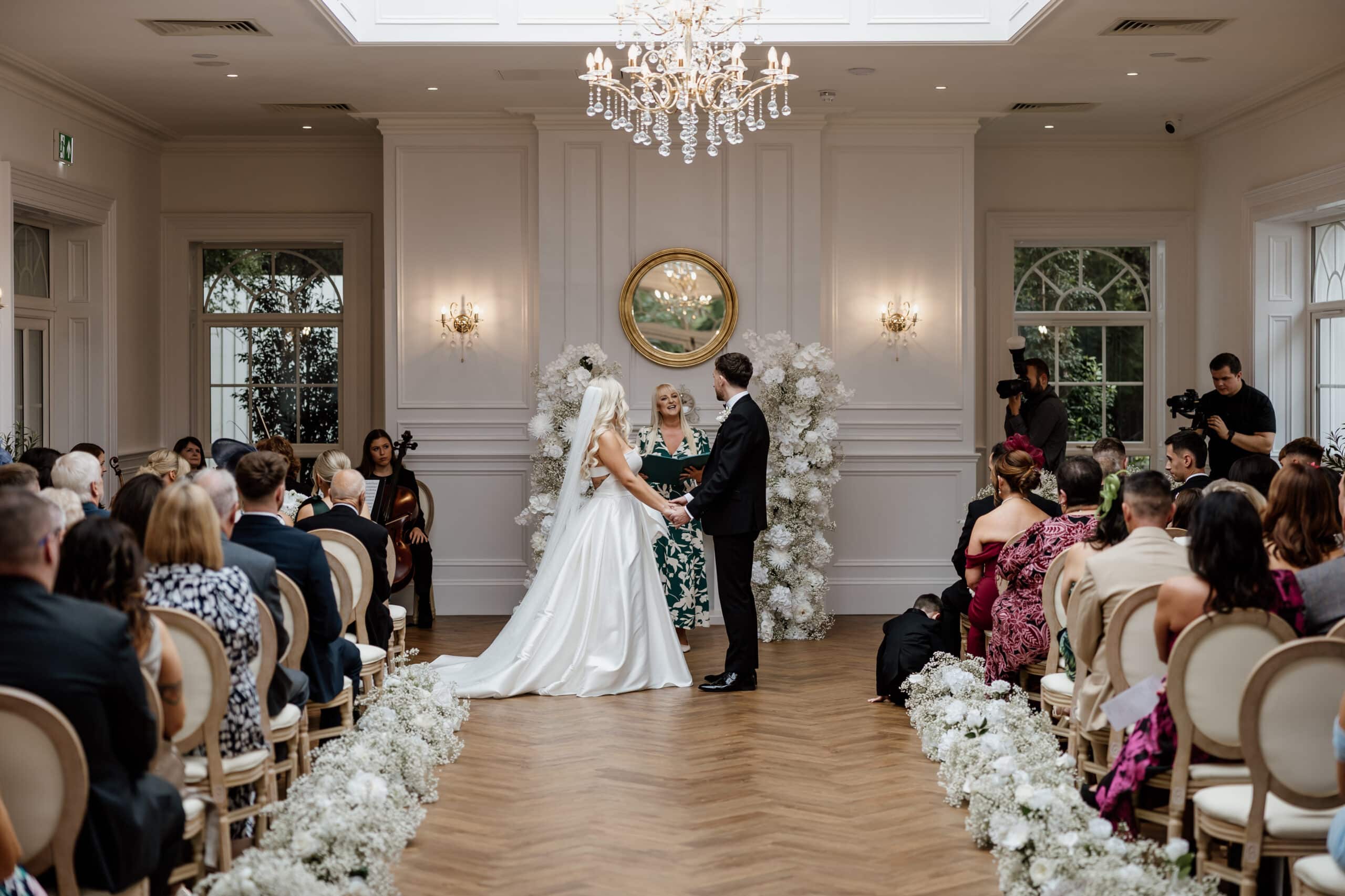 Bride and groom exchange vows in elegantly decorated indoor wedding ceremony.