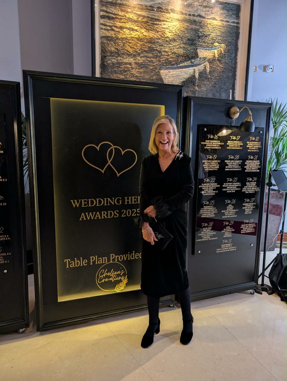 Woman in black dress standing in front of a Wedding Heroes Awards 2025 sign.